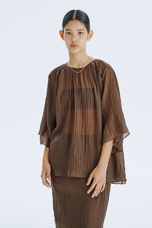 부드러운 촉감이 돋보이는 브라운 컬러의 플리세 블라우스입니다. 얇고 가벼운 텐셀 80%와 나일론 20% 혼방 소재로 제작되어 시원하고 편안한 착용감을 선사하며, 은은하게 비치는 시스루 디자인과 볼륨감 있는 소매 라인이 우아한 분위기를 더합니다. 라운드 넥, 루즈핏, 반소매 기장으로 디자인되어 일상에서 미니멀하면서도 세련된 스타일을 연출할 수 있으며, 다양한 아이템과 레이어드하여 개성 있는 룩을 완성할 수 있습니다.
