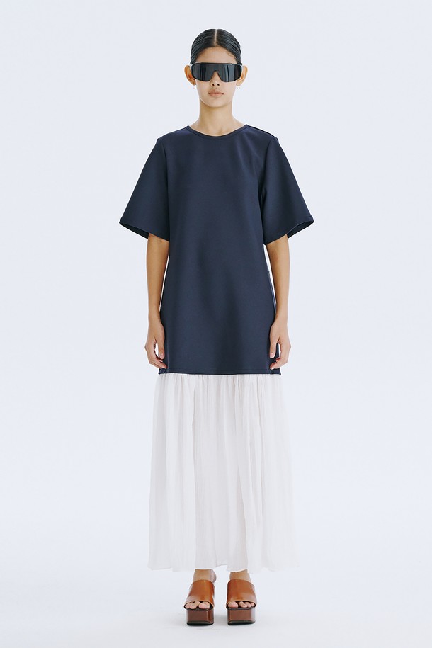 네이비 컬러의 Bare Back 셔링 드레스는 여성스러운 매력을 돋보이게 하는 데일리 원피스입니다. 얇고 쉬어한 촉감의 폴리에스테르, 스판덱스, 텐셀, 나일론 혼방 소재로 제작되어 봄, 여름 시즌에 시원하게 착용할 수 있습니다. U넥 라인과 플레어 치마, 반소매 디자인에 백 라인 오픈과 셔링 디테일, 리본 장식이 더해져 우아하면서도 베이직한 스타일을 연출합니다.
