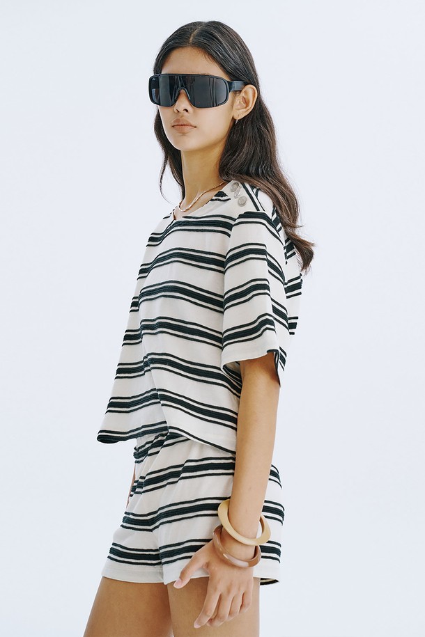 크리미한 색상의 스트라이프 자카드 니트 쇼츠입니다. 부드러운 면 소재로 제작되어 데일리 및 홈웨어로 편안하게 착용 가능하며, 허리 전체 밴딩 처리로 활동성을 높였습니다. 다리 라인을 더욱 길고 슬림하게 연출해 주는 디자인으로, 여름철 클래식하면서도 캐주얼한 스타일을 완성해 보세요.
