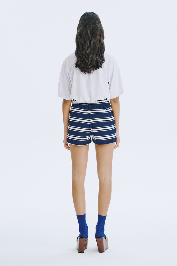 네이비 컬러의 스트라이프 자카드 니트 쇼츠는 여름철 데일리 및 홈웨어룩에 활용하기 좋은 여성 숏팬츠입니다. 면 소재로 제작되어 얇고 시원하며, 허리 전체 밴딩 처리로 편안한 착용감을 선사합니다. 클래식하면서도 캐주얼한 무드를 동시에 연출하며, 독특한 스트라이프 패턴과 레귤러핏 디자인으로 다리 라인을 더욱 길고 슬림하게 보이게 합니다.
