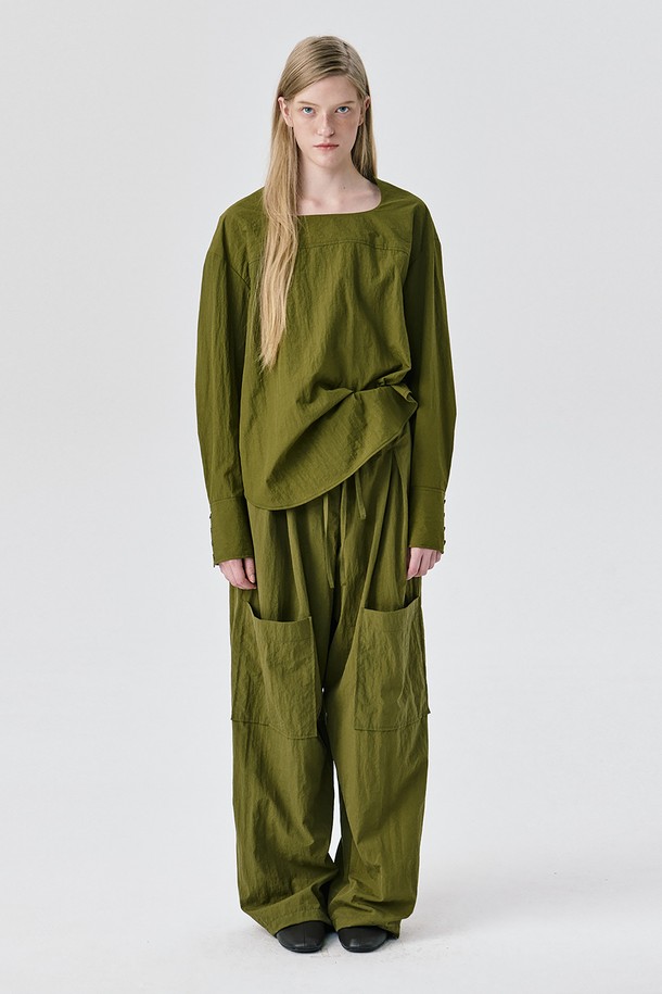 카키 색상의 Yoke Top (요크 탑) 블라우스입니다. 미니멀하고 모던한 스타일로, 가을과 겨울에 어울리는 긴 소매 디자인입니다. 나일론 소재로 제작되어 드라이한 촉감을 선사하며, 얇은 두께감으로 편안하게 착용 가능합니다. 요크 절개 디테일과 구조적인 실루엣, 은은한 광택감이 특징이며, 아방가르드한 무드를 연출합니다. 오피스룩, 출근룩, 겨울 데일리룩 등 다양한 TPO에 활용할 수 있으며, 미니멀, 클래식, 시크 스타일을 즐기는 여성분들께 추천합니다.
