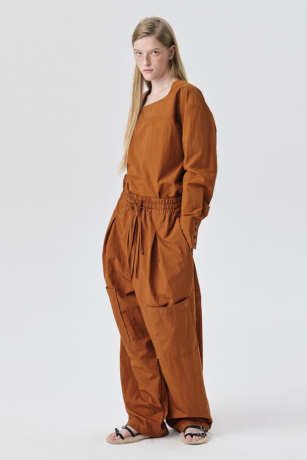 Yoke Top_브릭은 여성스러운 무드를 연출하는 블라우스입니다. 얇은 두께감의 나일론 소재로 제작되어 가을과 겨울에 적합하며 드라이한 촉감으로 편안한 착용감을 선사합니다. 톤 다운된 브릭 컬러와 미니멀, 모던, 아방가르드 스타일을 넘나드는 디자인이 특징입니다. 요크 절개 디테일과 구조적인 실루엣, 은은한 광택감이 돋보이며, 루즈핏으로 편안하게 착용 가능합니다. 출근룩, 오피스룩, 모임룩 등 다양한 TPO에 활용 가능하며 셋업 스타일로 시크하고 세련된 스타일링을 완성해보세요.
