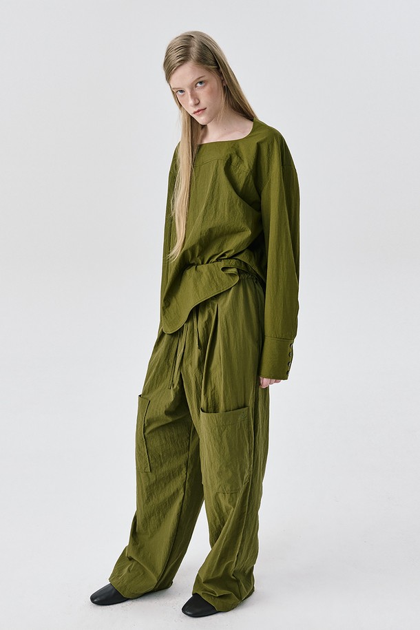 카키 색상의 Yoke Top (요크 탑) 블라우스입니다. 미니멀하고 모던한 스타일로, 가을과 겨울에 어울리는 긴 소매 디자인입니다. 나일론 소재로 제작되어 드라이한 촉감을 선사하며, 얇은 두께감으로 편안하게 착용 가능합니다. 요크 절개 디테일과 구조적인 실루엣, 은은한 광택감이 특징이며, 아방가르드한 무드를 연출합니다. 오피스룩, 출근룩, 겨울 데일리룩 등 다양한 TPO에 활용할 수 있으며, 미니멀, 클래식, 시크 스타일을 즐기는 여성분들께 추천합니다.
