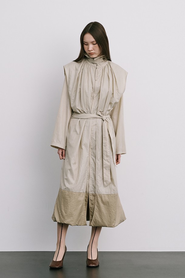 문(Moon) 자 모양의 베이지색 트렌치코트는 여성스러움을 강조한 미니멀하고 모던한 스타일의 아우터입니다. 얇은 나일론 소재로 제작되어 가볍고 산뜻한 착용감을 선사하며, 봄, 가을 간절기에 활용하기 좋습니다. 밑단이 어깨선까지 연결되는 독특한 디자인과 허리 벨트 구성으로 시크한 분위기를 연출하며, 롱 기장과 루즈핏으로 편안하게 착용할 수 있습니다. 출근룩, 오피스룩, 데이트룩 등 다양한 TPO에 활용하여 클래식하면서도 세련된 스타일을 완성해 보세요.
