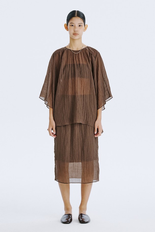 부드러운 촉감이 돋보이는 브라운 컬러의 플리세 블라우스입니다. 얇고 가벼운 텐셀 80%와 나일론 20% 혼방 소재로 제작되어 시원하고 편안한 착용감을 선사하며, 은은하게 비치는 시스루 디자인과 볼륨감 있는 소매 라인이 우아한 분위기를 더합니다. 라운드 넥, 루즈핏, 반소매 기장으로 디자인되어 일상에서 미니멀하면서도 세련된 스타일을 연출할 수 있으며, 다양한 아이템과 레이어드하여 개성 있는 룩을 완성할 수 있습니다.
