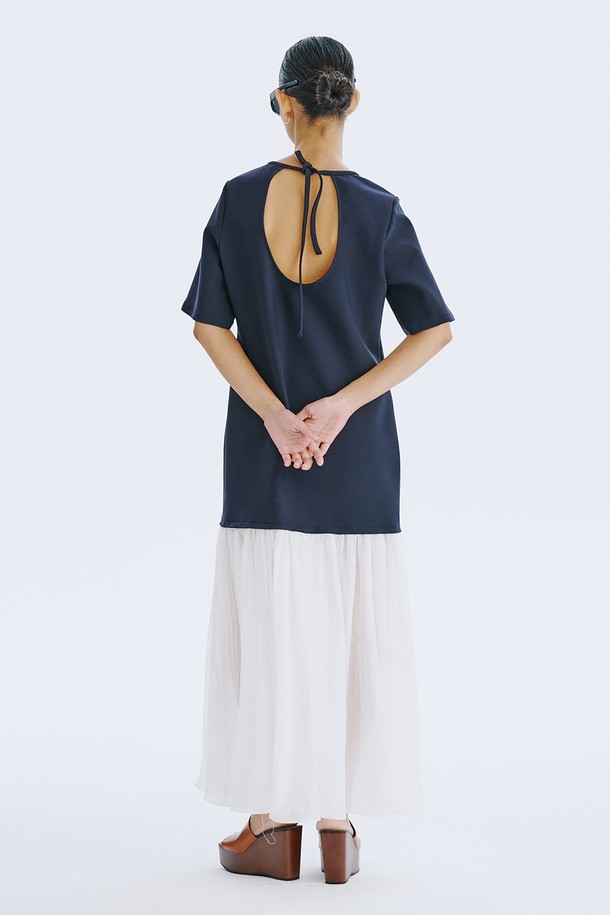 네이비 컬러의 Bare Back 셔링 드레스는 여성스러운 매력을 돋보이게 하는 데일리 원피스입니다. 얇고 쉬어한 촉감의 폴리에스테르, 스판덱스, 텐셀, 나일론 혼방 소재로 제작되어 봄, 여름 시즌에 시원하게 착용할 수 있습니다. U넥 라인과 플레어 치마, 반소매 디자인에 백 라인 오픈과 셔링 디테일, 리본 장식이 더해져 우아하면서도 베이직한 스타일을 연출합니다.
