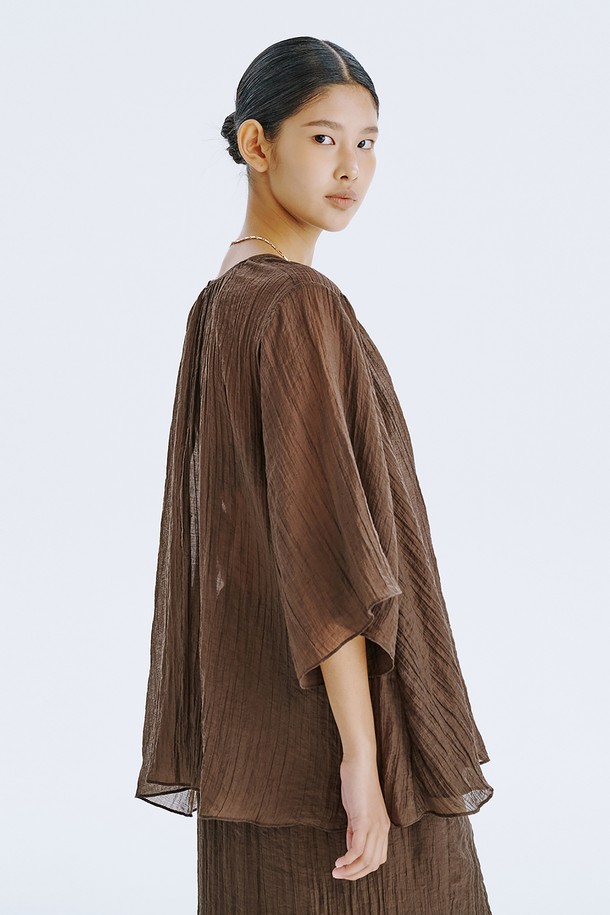 부드러운 촉감이 돋보이는 브라운 컬러의 플리세 블라우스입니다. 얇고 가벼운 텐셀 80%와 나일론 20% 혼방 소재로 제작되어 시원하고 편안한 착용감을 선사하며, 은은하게 비치는 시스루 디자인과 볼륨감 있는 소매 라인이 우아한 분위기를 더합니다. 라운드 넥, 루즈핏, 반소매 기장으로 디자인되어 일상에서 미니멀하면서도 세련된 스타일을 연출할 수 있으며, 다양한 아이템과 레이어드하여 개성 있는 룩을 완성할 수 있습니다.
