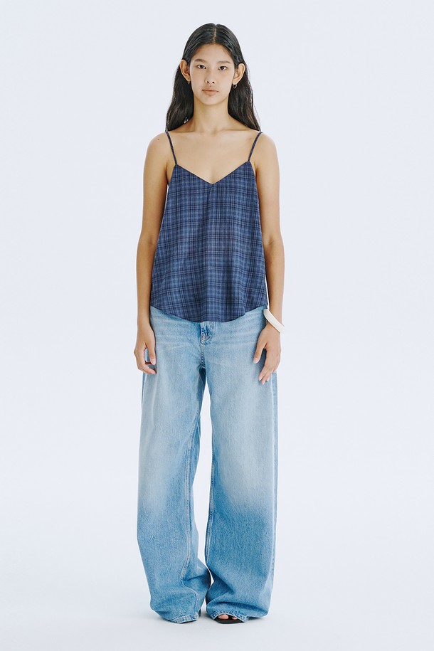 네이비 컬러의 체크 패턴이 돋보이는 민소매 탑입니다. 부드러운 면 80%와 레이온 20% 혼방 소재로 제작되어 시원하고 편안한 착용감을 선사하며, 브이넥 디자인에 아일렛 디테일과 끈 조절이 가능한 특징이 있습니다. 여름철 일상룩에 클래식하면서도 미니멀한 포인트를 더해줄 레귤러핏 상의입니다.
