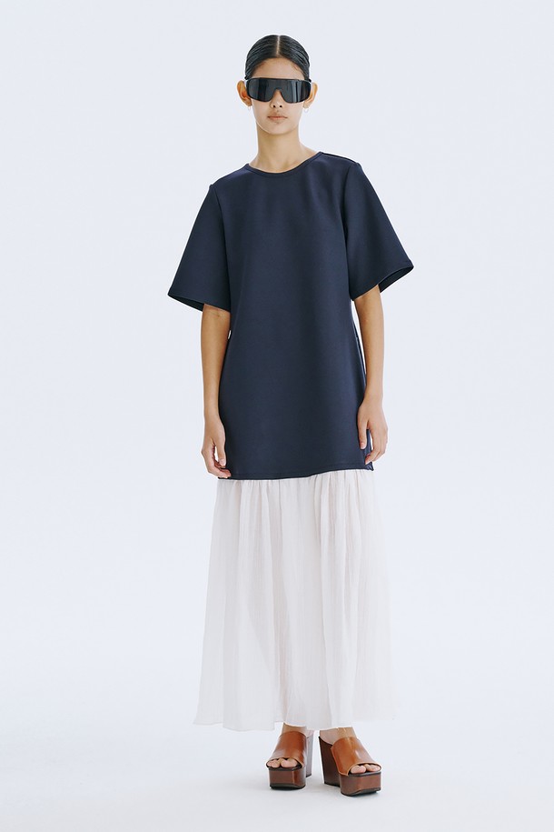 네이비 컬러의 Bare Back 셔링 드레스는 여성스러운 매력을 돋보이게 하는 데일리 원피스입니다. 얇고 쉬어한 촉감의 폴리에스테르, 스판덱스, 텐셀, 나일론 혼방 소재로 제작되어 봄, 여름 시즌에 시원하게 착용할 수 있습니다. U넥 라인과 플레어 치마, 반소매 디자인에 백 라인 오픈과 셔링 디테일, 리본 장식이 더해져 우아하면서도 베이직한 스타일을 연출합니다.
