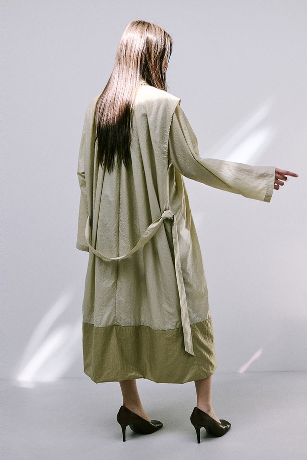 문(Moon) 자 모양의 베이지색 트렌치코트는 여성스러움을 강조한 미니멀하고 모던한 스타일의 아우터입니다. 얇은 나일론 소재로 제작되어 가볍고 산뜻한 착용감을 선사하며, 봄, 가을 간절기에 활용하기 좋습니다. 밑단이 어깨선까지 연결되는 독특한 디자인과 허리 벨트 구성으로 시크한 분위기를 연출하며, 롱 기장과 루즈핏으로 편안하게 착용할 수 있습니다. 출근룩, 오피스룩, 데이트룩 등 다양한 TPO에 활용하여 클래식하면서도 세련된 스타일을 완성해 보세요.
