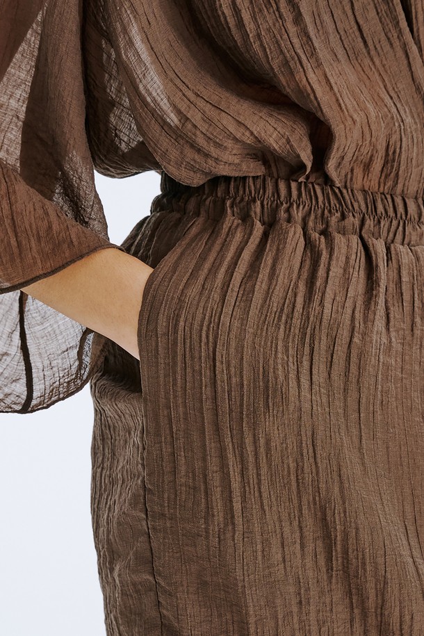 **Sheer Banding Skirt_Brown**

부드러운 텐셀 혼방 소재와 시스루 디자인이 특징인 여성용 H라인 스커트입니다. 브라운 컬러와 안감이 내장되어 비침 걱정 없이 시원하게 여름을 즐길 수 있습니다. 허리 밴딩 처리로 편안한 착용감을 선사하며, 미니멀하고 베이직한 스타일을 연출합니다.
