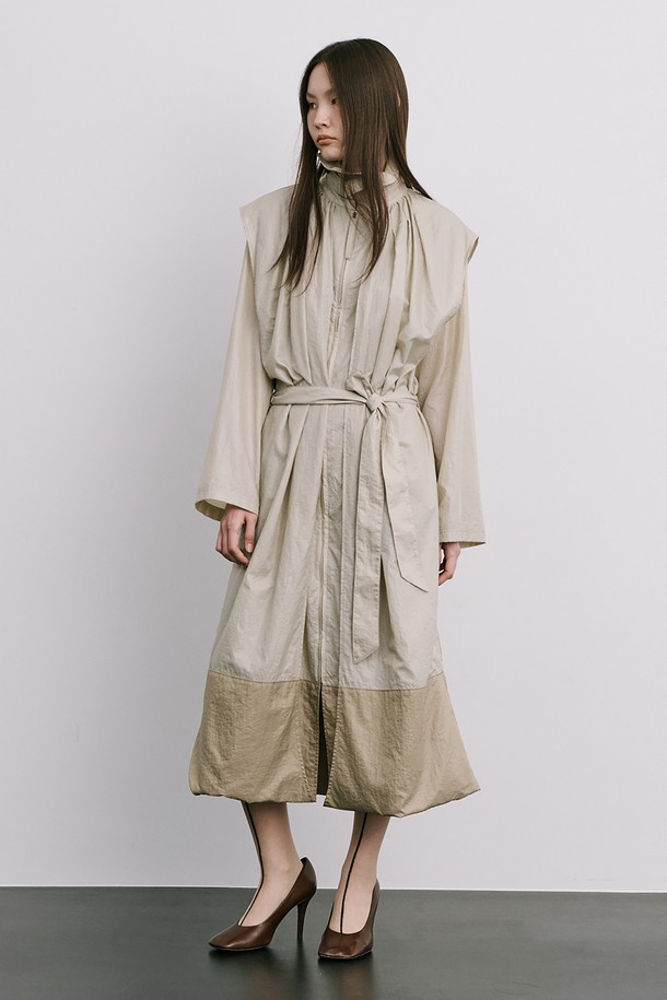 문(Moon) 자 모양의 베이지색 트렌치코트는 여성스러움을 강조한 미니멀하고 모던한 스타일의 아우터입니다. 얇은 나일론 소재로 제작되어 가볍고 산뜻한 착용감을 선사하며, 봄, 가을 간절기에 활용하기 좋습니다. 밑단이 어깨선까지 연결되는 독특한 디자인과 허리 벨트 구성으로 시크한 분위기를 연출하며, 롱 기장과 루즈핏으로 편안하게 착용할 수 있습니다. 출근룩, 오피스룩, 데이트룩 등 다양한 TPO에 활용하여 클래식하면서도 세련된 스타일을 완성해 보세요.
