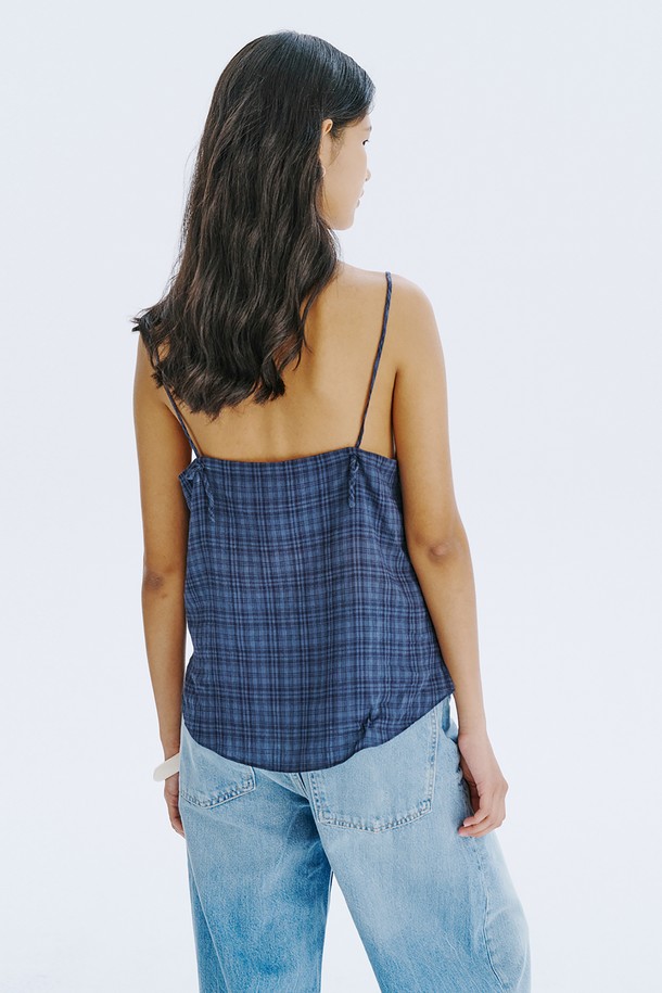 네이비 컬러의 체크 패턴이 돋보이는 민소매 탑입니다. 부드러운 면 80%와 레이온 20% 혼방 소재로 제작되어 시원하고 편안한 착용감을 선사하며, 브이넥 디자인에 아일렛 디테일과 끈 조절이 가능한 특징이 있습니다. 여름철 일상룩에 클래식하면서도 미니멀한 포인트를 더해줄 레귤러핏 상의입니다.

