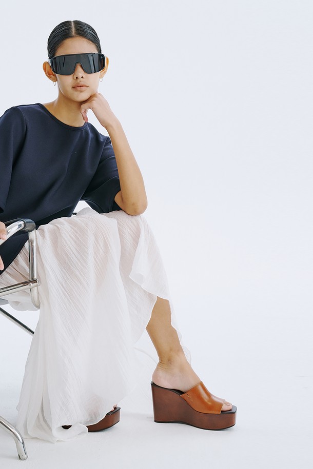 네이비 컬러의 Bare Back 셔링 드레스는 여성스러운 매력을 돋보이게 하는 데일리 원피스입니다. 얇고 쉬어한 촉감의 폴리에스테르, 스판덱스, 텐셀, 나일론 혼방 소재로 제작되어 봄, 여름 시즌에 시원하게 착용할 수 있습니다. U넥 라인과 플레어 치마, 반소매 디자인에 백 라인 오픈과 셔링 디테일, 리본 장식이 더해져 우아하면서도 베이직한 스타일을 연출합니다.
