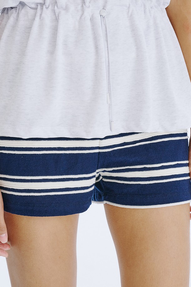 네이비 컬러의 스트라이프 자카드 니트 쇼츠는 여름철 데일리 및 홈웨어룩에 활용하기 좋은 여성 숏팬츠입니다. 면 소재로 제작되어 얇고 시원하며, 허리 전체 밴딩 처리로 편안한 착용감을 선사합니다. 클래식하면서도 캐주얼한 무드를 동시에 연출하며, 독특한 스트라이프 패턴과 레귤러핏 디자인으로 다리 라인을 더욱 길고 슬림하게 보이게 합니다.
