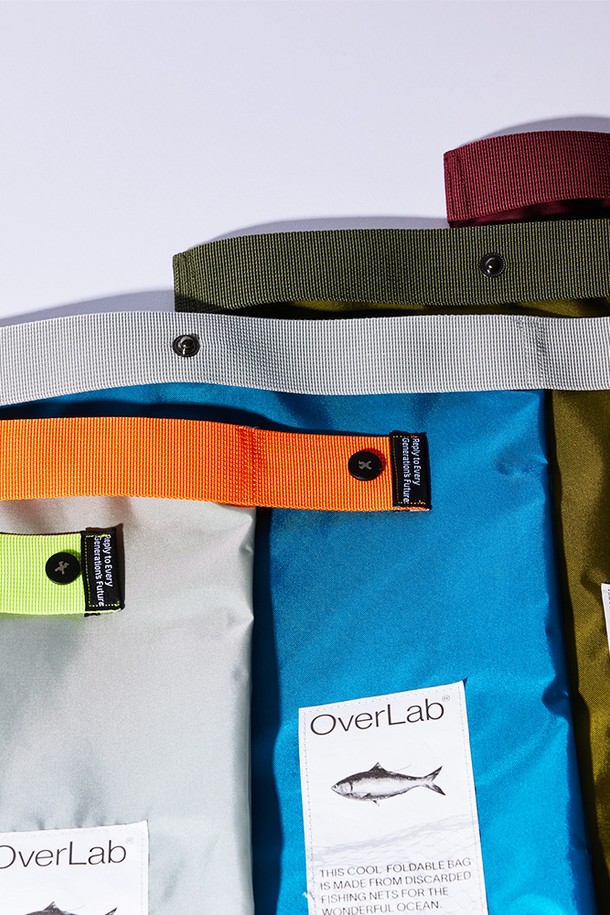 [OverLab] 오버랩 OVPR-119 폴더블백은 폐어망 재활용 원단을 사용하여 제작된 미니 사이즈의 폴더블백입니다. 남녀 모두 사용 가능하며, 사각형 무지 디자인에 단추 장식이 포인트입니다. 방수, 접이식, 경량, 속건, 발수 기능을 갖춰 일상과 여행에서 편리하게 사용할 수 있으며, 주먹 사이즈로 접어 보관할 수 있어 휴대성이 뛰어납니다.
