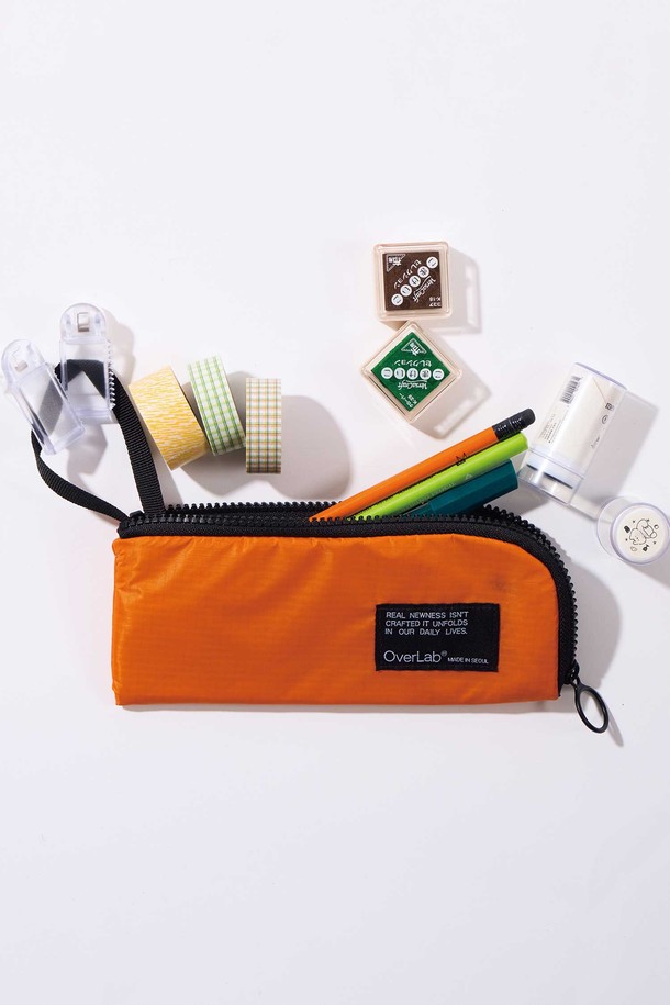 OverLab의 OVPR-130 Holdy 케이스는 3개의 분리 수납공간과 멀티 스트랩, 접이식 덮개로 실용성을 높인 펜슬 케이스입니다. 더블립스탑 소재를 사용하여 경량, UV 차단, 속건, 발수, 생활 방수 기능을 갖췄으며, L자형 이중 지퍼 구조로 내구성을 강화했습니다. 블랙, 네이비, 라임, 오렌지, 퍼플, 라이트 퍼플 등 다양한 색상 옵션으로 제공됩니다.

