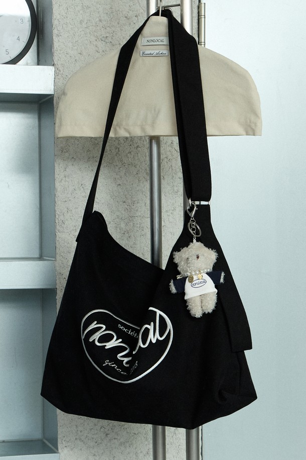 세련된 로고 자수 디테일이 돋보이는 블랙 에코백입니다. 면 소재로 제작되어 튼튼하며, 숄더백과 크로스백으로 활용 가능한 실용적인 디자인입니다. 넉넉한 수납 공간과 조절 가능한 스트랩, 액세서리 부착 기능으로 데일리룩에 클래식하고 베이직한 포인트를 더해줍니다.
