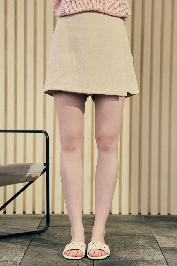 린넨과 면 혼방 소재로 제작된 라이트 베이지 색상의 랩 스커트 팬츠입니다. 대각선 랩 디자인이 특징이며, 스커트를 레이어드한 듯한 룩을 연출할 수 있습니다. 얇은 두께와 시원한 촉감으로 여름철 일상복으로 적합하며, 미니멀하고 페미닌한 캐주얼 스타일을 완성합니다.
