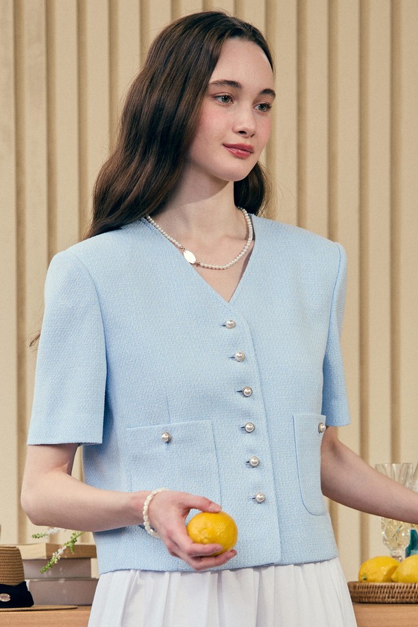 V넥 디자인이 돋보이는 블루 트위드 하프 슬리브 자켓입니다. 얇은 안감과 외부 포켓, 골드 진주 버튼 디테일이 특징이며, 폴리에스테르와 비스코스 혼방 소재로 제작되어 봄, 여름철 일상복으로 미니멀하고 엘레강스한 스타일을 연출할 수 있습니다. 트위드 원단 변형을 최소화하여 제작된 레귤러핏의 자켓입니다.
