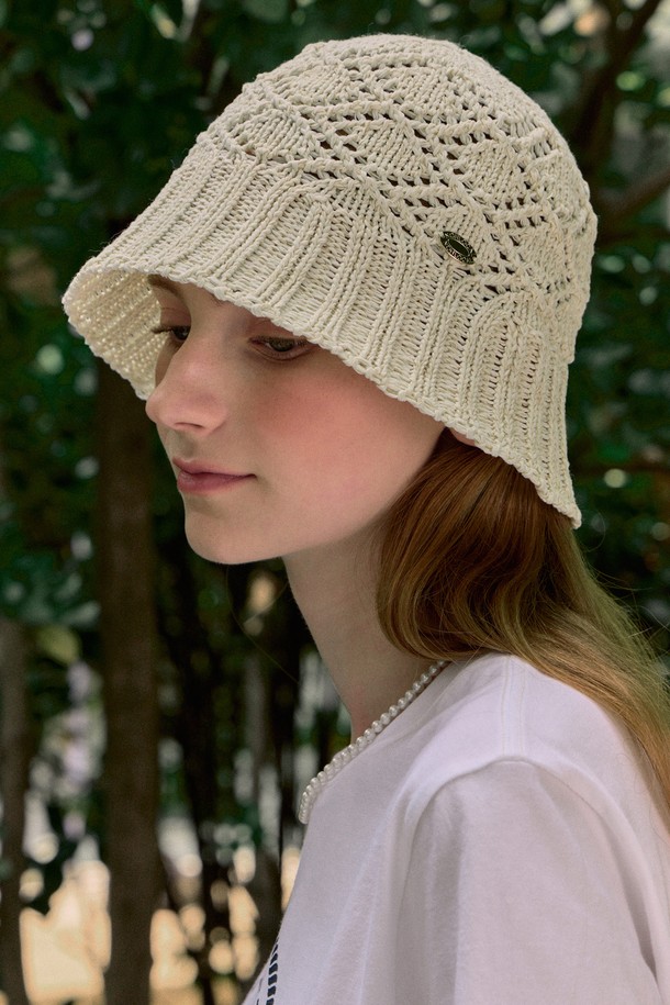 아이보리 컬러의 크로쉐 니트 버킷햇입니다. 부드러운 촉감의 폴리에스테르 소재로 제작되었으며, 통기성이 뛰어나 여름철에도 시원하게 착용할 수 있습니다. 프리 사이즈(둘레 58cm)로 편안한 실루엣을 제공하며, 24cm 모자 깊이와 유연한 구조로 디자인되었습니다. 
