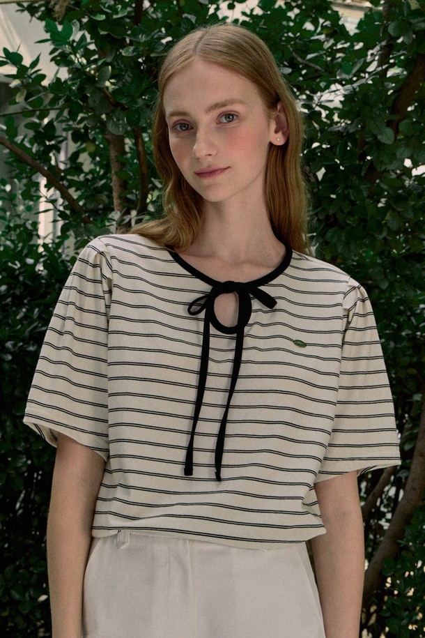 **Ribbon Stripe Puff Sleeve T-shirt - Black**

부드러운 면 소재의 블랙 컬러 티셔츠로, 페미닌한 무드를 연출하는 여성 상의입니다. 봄, 여름 시즌에 어울리는 얇은 두께감과 레귤러 핏으로 편안하게 착용할 수 있으며, 리본넥과 퍼프 소매 디테일, 숄더 턱 디테일이 특징입니다. 스트라이프 패턴과 네크라인 바인딩 스티치, 메탈 라벨 포인트가 더해져 세련된 스타일을 완성합니다.
