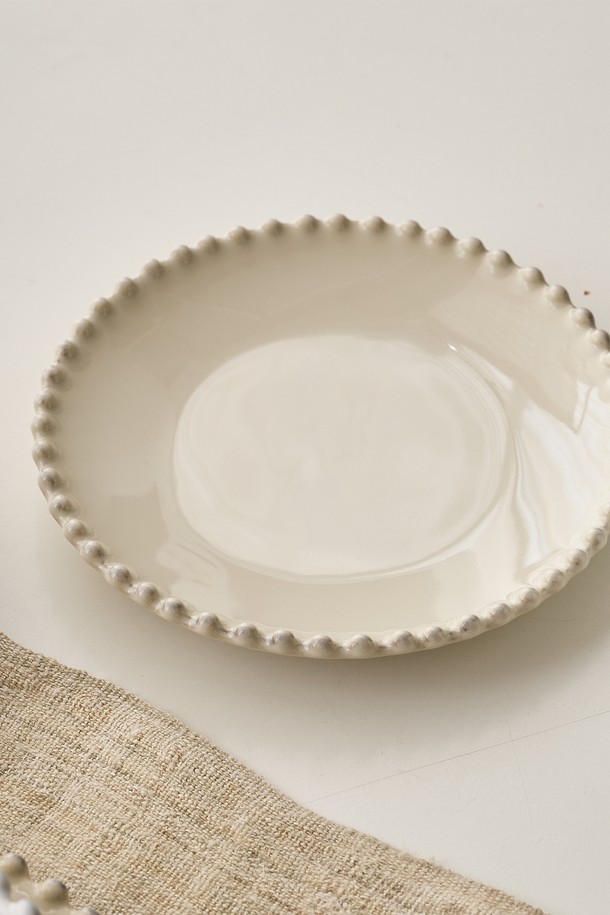 Costa Nova 펄 크림 17cm 브래드 접시는 파인 스톤웨어 소재로 제작되어 18세기 유럽 도자기를 재해석한 세미클래식 디자인을 선보입니다. 빛의 각도에 따라 은은하게 변하는 크림 컬러와 비정형 테두리, 내추럴한 디자인이 조화롭게 어우러져 주방에 우아함을 더합니다. 오븐, 전자레인지, 냉동고, 식기세척기 사용이 가능하여 실용성을 높였으며, 수작업으로 제작되어 제품마다 미세한 차이가 있다는 점을 참고해주세요.

