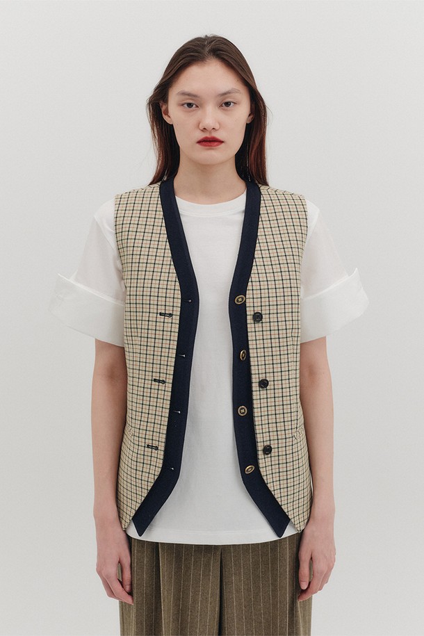 세련된 무드의 배색 버튼 베스트는 여성스러운 데이트룩, 모임룩, 오피스룩을 완성하는 아이템입니다. 부드러운 촉감의 이탈리아 울 혼방 소재와 안감으로 편안한 착용감을 선사하며, 봄, 가을 시즌에 활용하기 좋습니다. 브이넥 라인과 레귤러핏으로 클래식하고 베이직한 스타일을 연출하며, 크롭 기장과 민소매 디자인이 특징입니다. 배색 디자인과 파이핑 포켓, 골드 버튼 디테일이 돋보이며, 체크 패턴이 세련된 포인트를 더합니다. 싱글 버튼 여밈으로 간편하게 착용할 수 있습니다.
