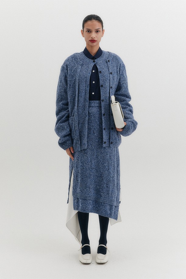 모던한 감각의 언밸런스 니트 스커트 - 블루입니다. 부드러운 울 소재로 제작되어 가을, 겨울 시즌에 따뜻하게 착용할 수 있습니다. 체크 패턴과 사이드 컷아웃 디테일, 레이어드 배색 밑단이 특징이며, 니트 가디건과 셋업으로도 연출 가능합니다. 데이트룩, 모임룩, 출근룩 등 다양한 TPO에 클래식, 미니멀, 시크한 스타일로 활용하기 좋습니다. 언밸런스 디자인으로 세련된 핏을 선사합니다.
