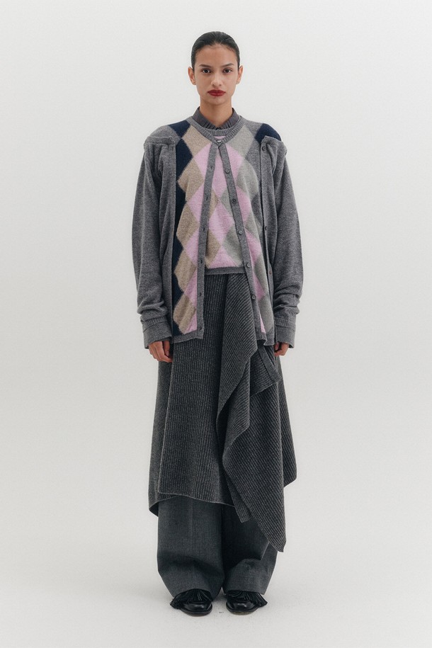 모던하고 미니멀한 무드의 레이어드 니트 스커트입니다. 부드러운 울 소재로 제작되어 가을, 겨울 시즌에 따뜻하게 착용할 수 있습니다. 언밸런스한 치마 핏과 케이프 실루엣, 드레이프 디테일이 특징이며, 사이드 버튼으로 간편하게 여밈이 가능합니다. 루즈핏으로 편안한 착용감을 선사하며, 미디 기장으로 다양한 스타일을 연출하기 좋습니다. 모임룩, 출근룩 등 TPO에 맞춰 미니멀, 클래식, 시크한 스타일을 완성해보세요.
