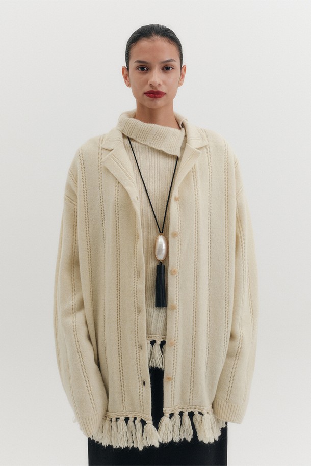 **프린지 니트 가디건 - 크림**

포근한 알파카 블렌드 울 소재로 제작된 여성용 "프린지" 니트 가디건입니다. 부드러운 촉감과 두꺼운 두께감으로 가을, 겨울철 따뜻하게 착용할 수 있습니다. 베이직하면서 클래식한 스타일로 데이트룩에 어울리며, 긴 소매와 루즈핏 디자인이 편안함을 더합니다. 헴라인의 프린지 디테일과 스트라이프 조직감이 돋보이는 크림 컬러의 카라 니트 가디건입니다.
