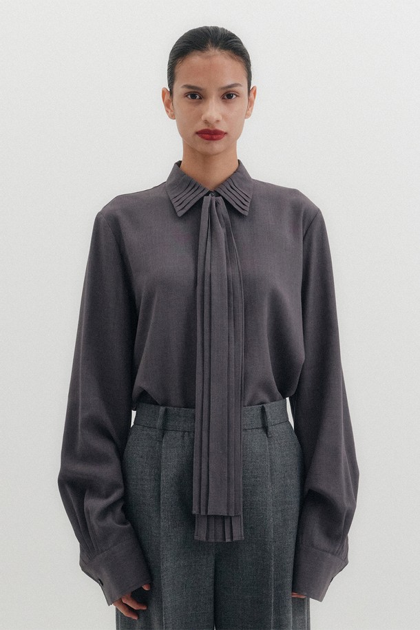 플리츠 카라 타이 셔츠 - 그레이는 여성스러운 실루엣을 연출하는 셔츠입니다. 부드러운 레이온과 폴리에스테르 혼방 소재로 제작되어 편안한 착용감을 선사합니다. 플리츠 카라와 타이 디테일이 클래식하면서도 엘레강스한 무드를 더하며, 루즈핏과 긴 소매 기장으로 여유로운 핏을 제공합니다. 얇은 두께감으로 봄, 가을 시즌에 활용하기 좋으며, 오피스룩, 출근룩, 모임룩 등 다양한 TPO에 맞춰 미니멀하고 시크한 스타일을 연출할 수 있습니다. 무지 디자인의 그레이 컬러로 어떤 하의와도 쉽게 매치하여 세련된 룩을 완성해보세요.
