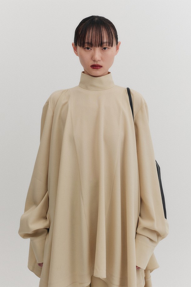 하이넥 플로우 블라우스 - 옐로우는 여성스러운 매력을 극대화하는 블라우스입니다. 부드러운 레이온과 폴리에스테르 혼방 소재로 제작되어 얇고 가벼운 착용감을 선사하며, 우아하고 엘레강스한 스타일을 연출합니다. 하이넥 디자인과 긴소매, 루즈핏 실루엣이 편안하면서도 세련된 분위기를 자아냅니다. 언밸런스 헴라인과 플레어 디테일, 골드 로즈 버튼 장식, 뒷면 버튼 여밈이 섬세함을 더하며, 드레이프 실루엣이 여성스러운 라인을 강조합니다. 데이트룩, 모임룩에 적합하며 클래식, 미니멀, 로맨틱 스타일을 즐기는 분들께 추천합니다.
