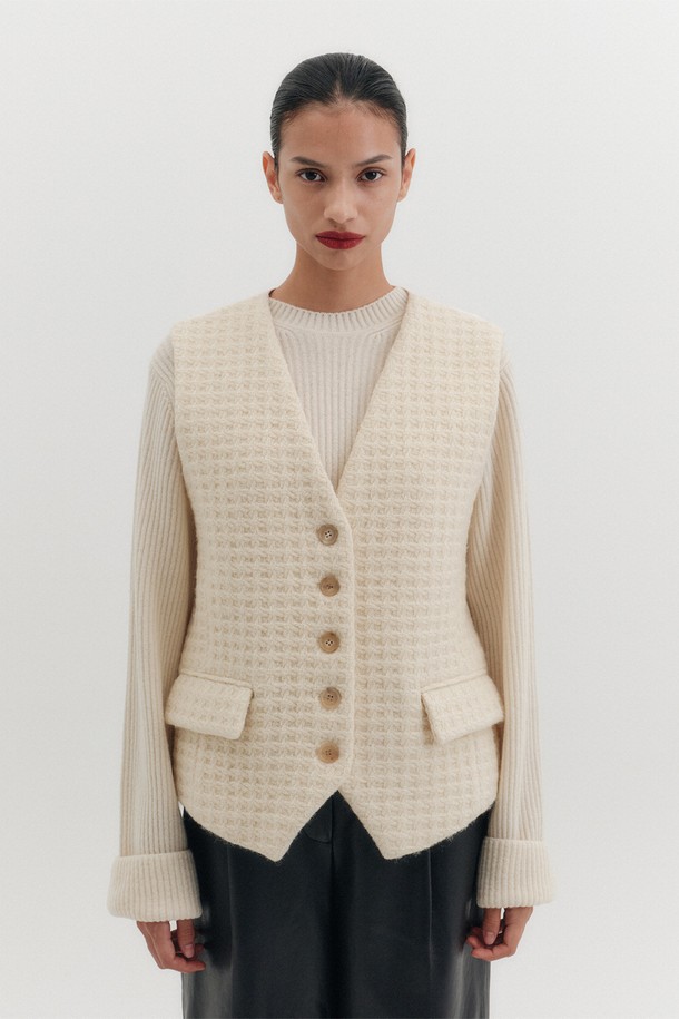 아이보리 컬러의 벨티드 테일러드 베스트는 여성스러운 실루엣을 연출합니다. 울, 레이온, 폴리에스테르 혼방 소재로 제작되어 고급스러운 텍스처와 편안한 착용감을 선사합니다. 브이넥 디자인과 민소매 스타일로 클래식하고 세련된 분위기를 더하며, 벨티드 디자인으로 허리 라인을 강조하여 더욱 슬림해 보이는 효과를 줍니다. 페이크 플랩 포켓 디테일이 돋보이며, 안감이 있어 안정적인 착용감을 제공합니다. 오피스룩, 모임룩, 소개팅룩 등 다양한 TPO에 활용할 수 있는 미니멀하고 시크한 아이템입니다.
