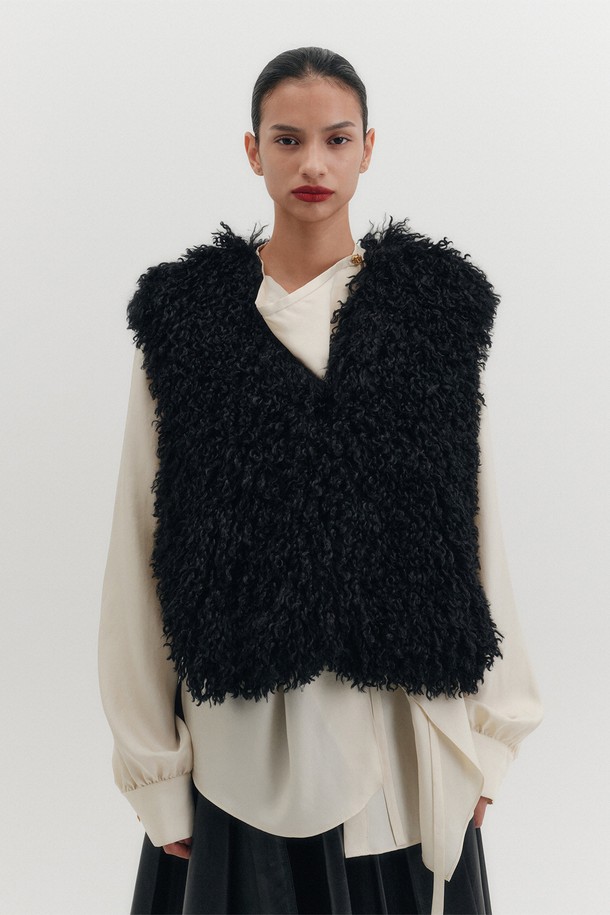 소프트 폭스 퍼 베스트 - 블랙은 우아하고 모던한 스타일을 연출하는 여성용 베스트입니다. 부드러운 촉감의 폴리에스테르 소재로 제작되어 가을과 겨울에 따뜻하게 착용할 수 있습니다. 크롭 기장에 오버핏으로 디자인되어 볼륨감 있는 실루엣을 선사하며, 오픈 스타일의 브이넥과 컬리한 텍스처가 특징입니다. 데이트룩, 모임룩, 연말 모임룩 등 다양한 TPO에 클래식, 미니멀, 시크한 스타일을 더해줍니다. 민소매 디자인으로 이너웨어에 따라 다양한 분위기를 연출할 수 있습니다.
