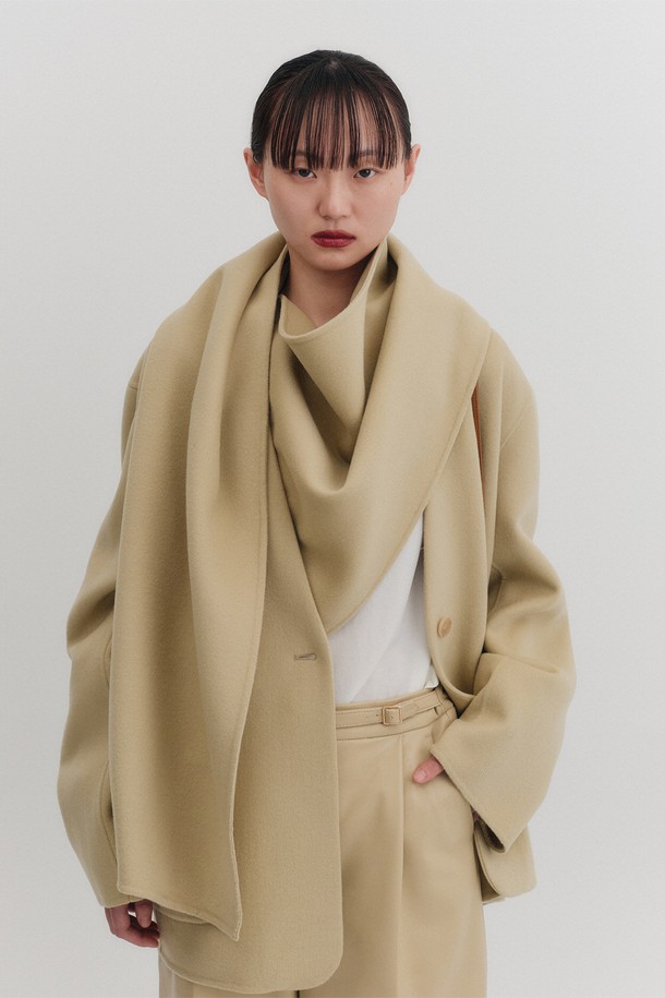 핸드메이드 머플러 자켓 - 라이트 베이지는 부드러운 울과 캐시미어 혼방 소재로 제작되어 가을, 겨울 시즌에 따뜻하게 착용할 수 있는 여성용 자켓입니다. 미니멀하고 클래식한 스타일로, 일상, 출근, 모임, 데이트 등 다양한 TPO에 활용 가능합니다. 라이트 베이지 컬러의 무지 디자인에 오버핏, 긴 소매, 논카라 코트 타입으로 시크한 매력을 더했습니다. 특히 탈부착 가능한 머플러가 있어 보온성을 높였으며, 싱글 버튼 여밈 방식과 핸드메이드 마감으로 고급스러운 퀄리티를 자랑합니다. 드라이클리닝을 권장합니다.
