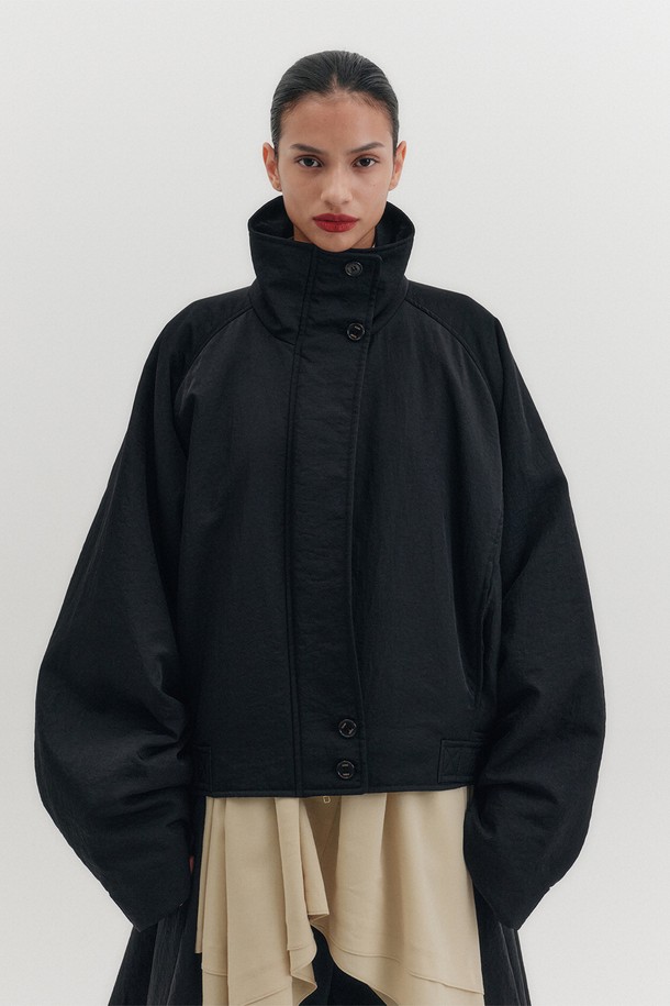 세련된 무드를 연출하는 여성용 블랙 트랜스포머블 점퍼입니다. 봄, 가을 시즌에 적합하며, 미니멀하고 시크한 스타일을 완성합니다. 버튼으로 분리 가능한 트랜스포머블 디자인으로, 자켓과 스커트 각각 단독 연출이 가능하여 다양한 룩을 연출할 수 있습니다. 오버핏의 두꺼운 나일론 소재로 제작되었으며, 하이넥 디자인과 언밸런스 밑단이 특징입니다. 데이트룩, 모임룩, 출근룩 등 TPO에 구애받지 않고 폭넓게 활용할 수 있습니다.
