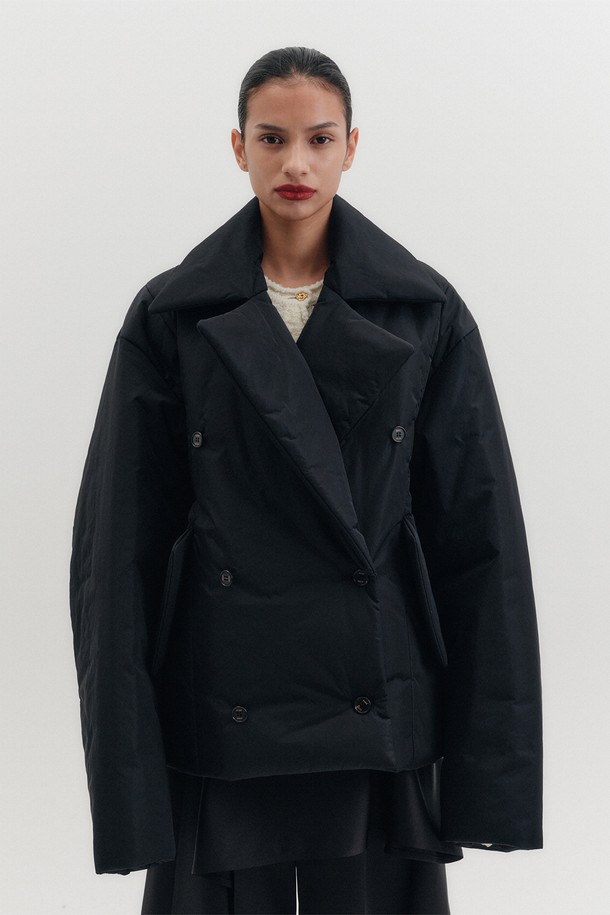 세련된 스타일을 완성하는 오버사이즈 패디드 숏 코트 - 블랙입니다. 래글런 슬리브와 사이드 플랩 포켓, 더블브레스트 디자인이 돋보이는 모던하고 클래식한 디자인입니다. 넉넉한 오버핏으로 편안한 착용감을 선사하며, 나일론과 폴리에스테르 혼방 소재로 제작되어 가을, 겨울 시즌 따뜻하게 입을 수 있습니다. 출근룩, 오피스룩, 모임룩 등 다양한 TPO에 활용 가능한 미니멀하고 시크한 아이템입니다. 두꺼운 두께감과 긴 소매 기장으로 보온성을 높였습니다.
