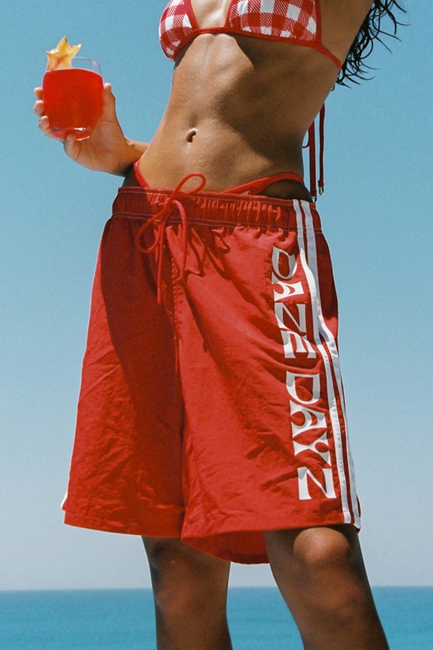 레드 컬러의 SASSY BOY TRUNK는 스포티하고 캐주얼한 무드를 연출하며, 여름철 수영, 비치웨어, 데일리룩으로 활용하기 좋습니다. 얇고 가벼운 나일론 소재에 와이드핏으로 제작되었으며, 스트라이프 및 DAZE DAYZ 로고 프린트 패턴이 돋보입니다. 밴딩, 드로우스트링, 옆선 슬릿, 사이드 슬릿 포켓, 뒷포켓, 매쉬 안감 등의 디테일을 갖춘 무릎 아래 기장의 트렁크 쇼츠입니다.
