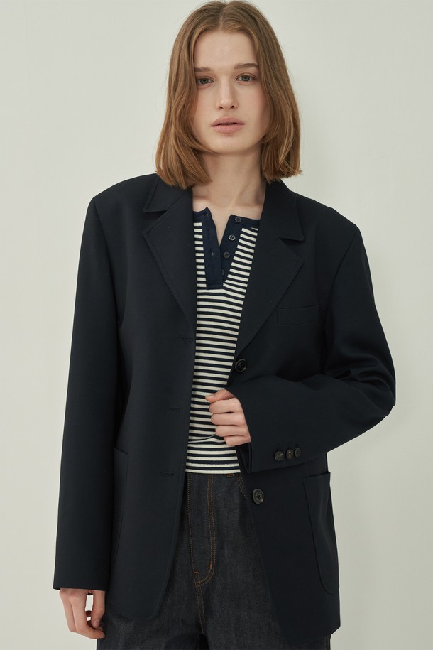 네이비 컬러의 프렌치 클래식 재킷입니다. 울 소재에 두꺼운 두께감으로 제작되어, 봄, 가을 시즌에 착용하기 좋습니다. 테일러드 칼라와 싱글 버튼 여밈 방식으로 클래식한 매력을 더하며, 레귤러 핏으로 편안하게 착용 가능합니다. 테일러드 칼라와 포켓 디테일이 돋보이는 디자인으로, 오피스룩, 출근룩, 모임룩 등 다양한 TPO에 활용할 수 있습니다. 미니멀하면서도 클래식한 스타일을 연출하기에 적합합니다.
