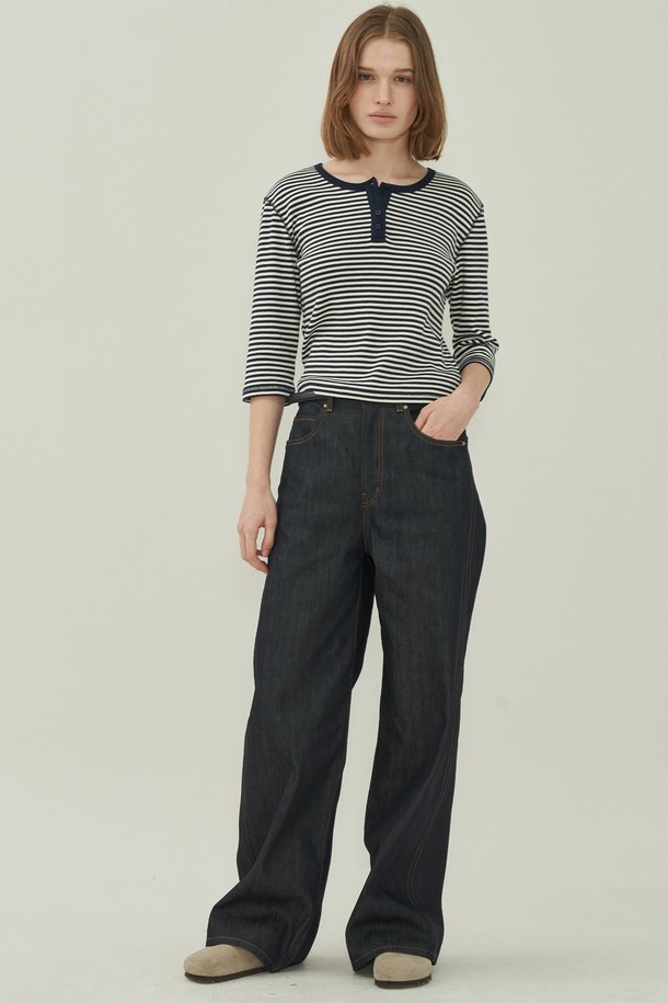 네이비와 화이트 스트라이프 패턴이 시원한 헨리넥 슬림 티셔츠입니다. 부드러운 면 소재로 제작되어 편안한 착용감을 선사하며, 봄, 여름 시즌 데이트룩이나 산책룩에 잘 어울립니다. 슬림핏 디자인으로 여성스러운 실루엣을 강조하며, 얇은 두께감과 반소매 기장으로 시원하게 입을 수 있습니다. 헨리넥 라인과 리본 디테일이 캐주얼하면서도 미니멀한 스타일을 완성하며, 다양한 하의와 매치하여 클래식한 무드를 연출할 수 있습니다.
