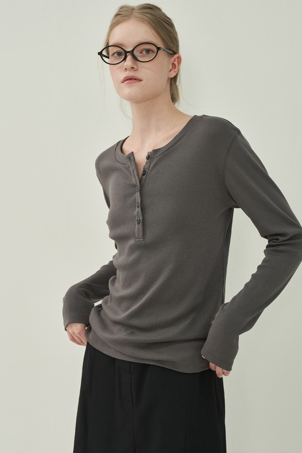 차분하고 세련된 무드의 헨리넥 클래식 티셔츠입니다. 부드러운 면 소재로 제작되어 편안한 착용감을 선사하며, 레귤러핏으로 제작되어 깔끔한 실루엣을 연출합니다. 차콜 컬러와 무지 디자인은 어떤 스타일에도 잘 어울려 활용도가 높습니다. 헨리넥 디자인과 버튼 디테일이 클래식한 멋을 더하며, 봄, 가을 출근룩 또는 비즈니스 캐주얼에 적합합니다. 긴소매 기장으로 간절기에 유용하게 착용할 수 있습니다.
