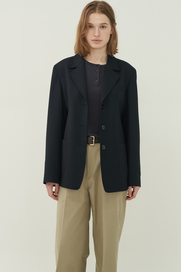 네이비 컬러의 프렌치 클래식 재킷입니다. 울 소재에 두꺼운 두께감으로 제작되어, 봄, 가을 시즌에 착용하기 좋습니다. 테일러드 칼라와 싱글 버튼 여밈 방식으로 클래식한 매력을 더하며, 레귤러 핏으로 편안하게 착용 가능합니다. 테일러드 칼라와 포켓 디테일이 돋보이는 디자인으로, 오피스룩, 출근룩, 모임룩 등 다양한 TPO에 활용할 수 있습니다. 미니멀하면서도 클래식한 스타일을 연출하기에 적합합니다.
