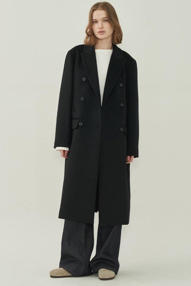**울 더블 롱 코트 - Black**

세련된 여성의 겨울 스타일을 완성할 울 더블 롱 코트입니다. 미니멀하고 클래식한 디자인으로 오피스룩, 출근룩, 모임룩 등 다양한 TPO에 활용 가능합니다. 블랙 컬러의 무지 디자인과 오버핏, 롱 기장, 테일러드 칼라, 그리고 더블 버튼 여밈 방식이 특징입니다. 두꺼운 울 소재로 제작되어 한겨울에도 따뜻하게 착용할 수 있으며, 포켓 디테일로 실용성을 더했습니다.
