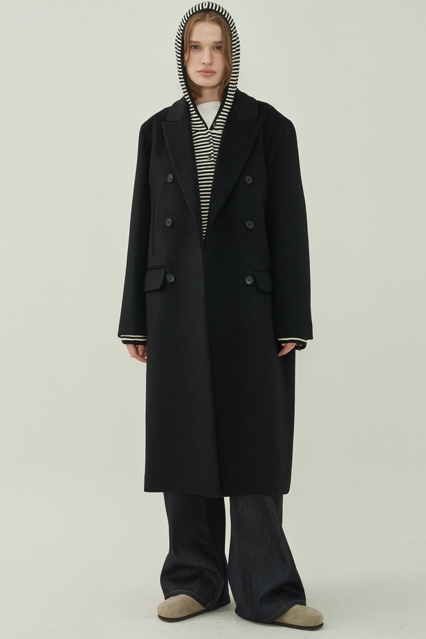 **울 더블 롱 코트 - Black**

세련된 여성의 겨울 스타일을 완성할 울 더블 롱 코트입니다. 미니멀하고 클래식한 디자인으로 오피스룩, 출근룩, 모임룩 등 다양한 TPO에 활용 가능합니다. 블랙 컬러의 무지 디자인과 오버핏, 롱 기장, 테일러드 칼라, 그리고 더블 버튼 여밈 방식이 특징입니다. 두꺼운 울 소재로 제작되어 한겨울에도 따뜻하게 착용할 수 있으며, 포켓 디테일로 실용성을 더했습니다.
