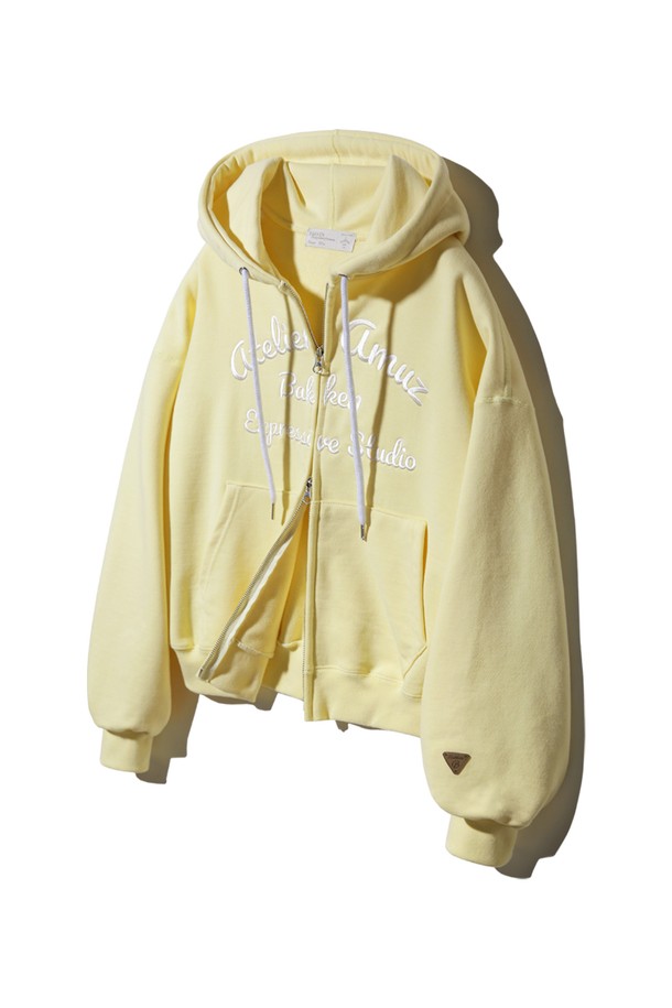 바켄 Atelier Amuz 후드 집업 BK79892_버터옐로우는 부드러운 면/폴리에스테르 혼방 소재에 두꺼운 두께감으로 제작되어 봄, 여름 시즌 캐주얼하게 즐기기 좋은 여성 후드 집업입니다. 버터옐로우, 스카이블루, 라일락 세 가지 파스텔톤 컬러로 출시되었으며, 2웨이 지퍼 더블 슬라이더, 새틴 자수, 가죽 패치, 플랫락 스티칭 디테일과 루즈핏, 벌룬핏의 넉넉한 핏이 특징입니다. 크롭 기장에 긴 소매, 집업 여밈 방식으로 편안함과 스타일리시함을 동시에 선사합니다.
