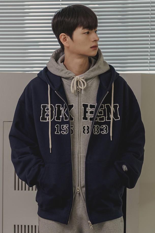 바켄 BKEN 1583 후드 집업 BK7990_네이비는 남녀공용으로 착용 가능한 캐주얼 스타일의 후드 집업입니다. 네이비, 멜란지 그레이, 차콜, 와인 4가지 컬러로 출시되었으며, 봄, 가을, 겨울 계절에 적합합니다. 고밀도 프렌치 테리 원단과 840g/yd 고중량으로 제작되어 부드러운 촉감과 단단한 조직감을 자랑하며, 오버핏 세미 크롭 기장으로 트렌디한 핏을 연출합니다.
