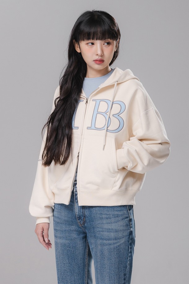 1583 Women semi crop 투웨이 후드집업 BK7992_크림은 캐주얼, 미니멀, 스트리트 스타일을 즐기는 여성들을 위한 세미 크롭핏 후드집업입니다. 부드러운 촉감의 면, 폴리에스테르 혼방 프렌치테리 원단으로 제작되어 봄, 가을에 착용하기 좋으며, 두꺼운 두께감으로 따뜻함을 더합니다. 2WAY 더블 슬라이더 지퍼와 타이포그래피 디자인, 새틴 자수 디테일이 돋보이며, 플랫락 스티치 마감으로 깔끔함을 더했습니다. 동네 마실룩, 산책룩에 편안하게 매치하여 미니멀하면서도 스타일리시한 룩을 연출해보세요.
