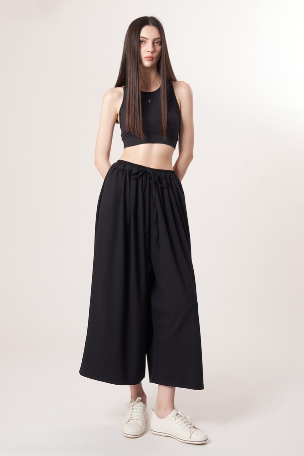 AU52PT33 F 와이드 크롭 팬츠_블랙은 미니멀하고 베이직한 스타일의 여성용 와이드 크롭 팬츠입니다. 봄, 여름, 가을 계절에 적합하며, 얇고 부드러운 촉감의 폴리에스테르, 레이온, 폴리우레탄 혼방 소재로 제작되어 편안한 착용감을 선사합니다. 허리 밴딩과 드로우스트링 디테일로 편안함을 더했으며, 넉넉한 루즈핏으로 활동성을 높였습니다. 데이트룩, 카페룩 등 다양한 TPO에 활용하기 좋으며, 남녀 공용으로 착용 가능합니다.

