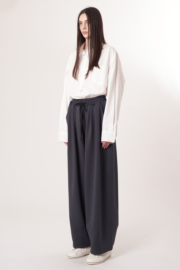 AU52PT39 더블 테크 와이드 팬츠_다크그레이는 미니멀, 스포티, 클래식 스타일을 아우르는 여성용 와이드 팬츠입니다. 사계절 착용 가능하며, 출근룩과 여행룩에 모두 잘 어울립니다. 다크그레이 컬러의 무지 디자인으로, 더블 레이어드 기능성 원단과 압축 가공 소재를 사용하여 두께감 있는 부드러운 촉감을 선사합니다. 밴딩 처리된 허리와 앞면 턱 디테일, 드로우스트링, 트랙팬츠 스타일이 특징이며 루즈핏으로 편안하게 착용할 수 있습니다.
